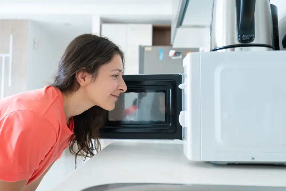 girl using toaster oven in kitchen
