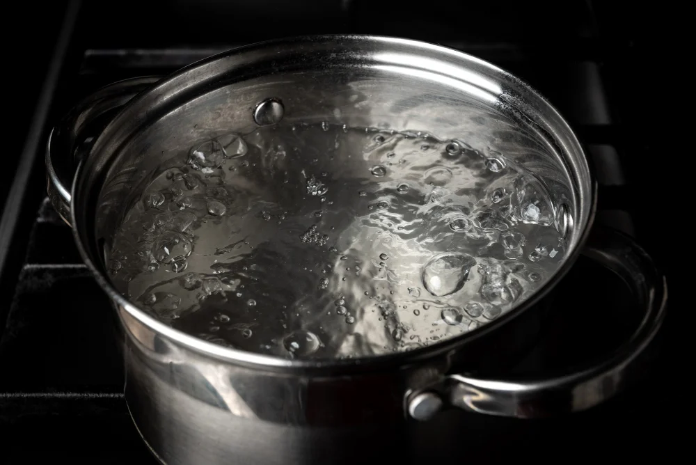 Boiling water in pan on stove kitchen sink drain