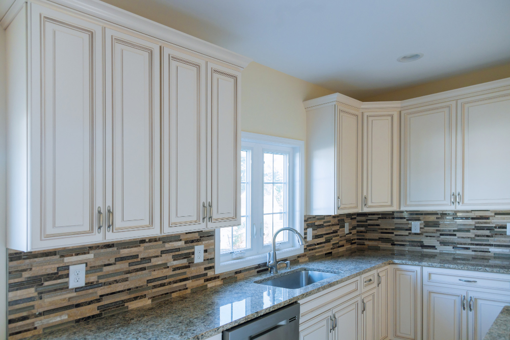 Clear Decluttered White Kitchen Cabinet with Granite Countertop Faucet Small Window