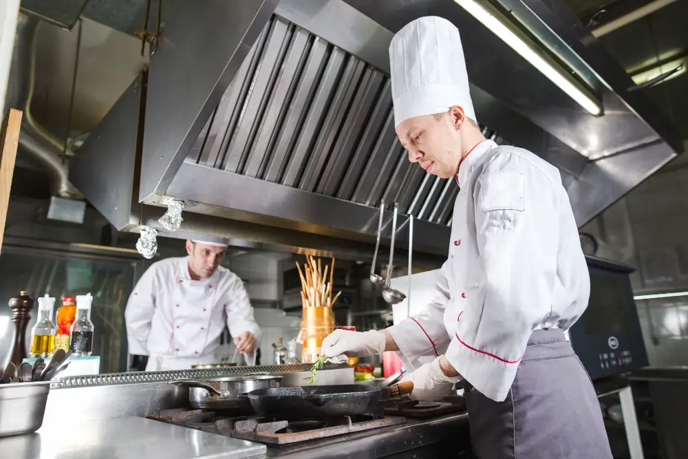 Factors Affecting Cleaning Commercial Kitchen Hood Frequency - Chefs Cooking in The Kitchen